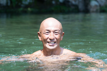Smiling Japanese bald head guy soaked in water