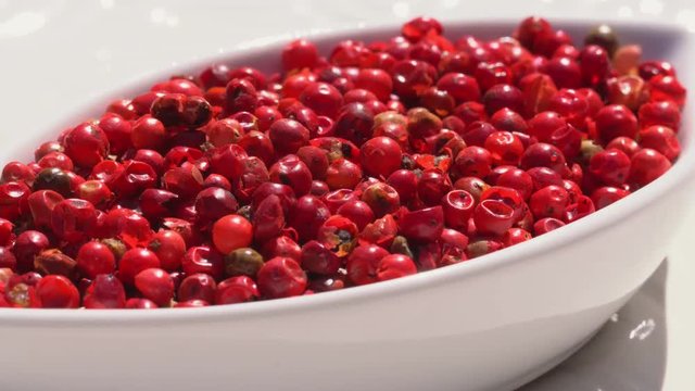 Dry spices pink pepper on a rotary table. 4K. Macroshooting.