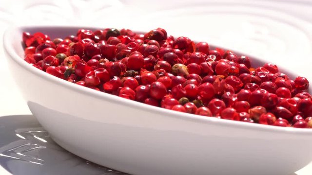 Dry spices pink pepper on a rotary table. 4K. Macroshooting.