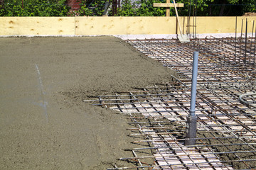 pouring concrete into prepared place with reinforced metal frame
