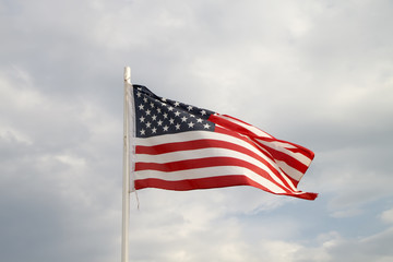 American flag on a blue sky with clouds background