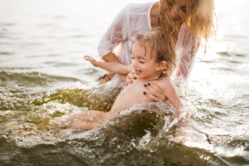 happy mother and daughter swimming together in river