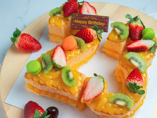 Happy birthday fresh fruit cake with Chocolate tag Number cake concept with strawberry kiwi fruit cake.