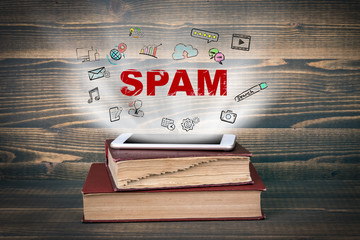 Spam. Concept cloud coming from screen of the phone, books on the desk