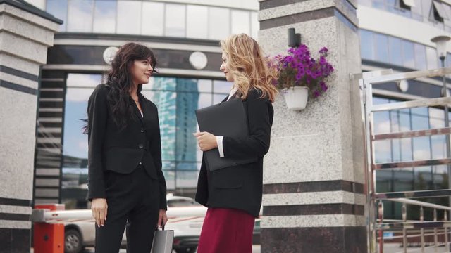 meeting of business partners outdoor. two business women in strict suits are talking
