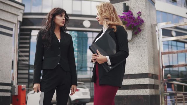 two attractive business women in formal suits outdoor.