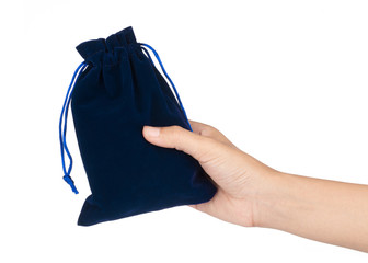 hand holding blue velvet bag isolated on white background
