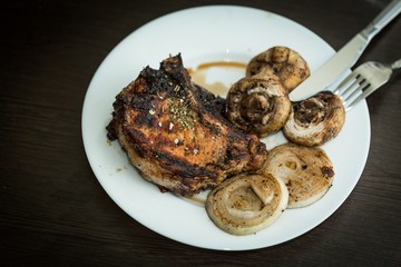 Grilled Steak, Mushrooms and Onion on the Plate with Cutlery -