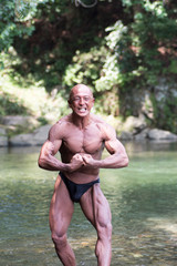 Japanese bald head bodybuilder posing the most muscular  at the river © Miyuki Satake