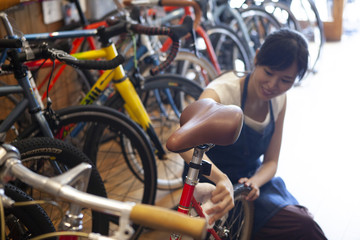 Fototapeta na wymiar 自転車をメンテナンスする女性