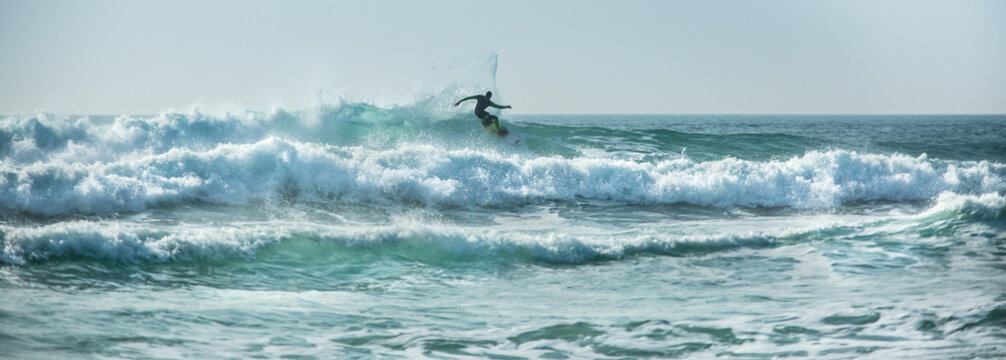 Silhouette surfer riding waves, Fistral, Newquay, Cornwall