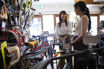 Obraz na płótnie Canvas 自転車ショップで楽しく会話する女性たち