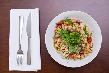 Plate of fusilli pasta with octopus and cherry tomatoes.
