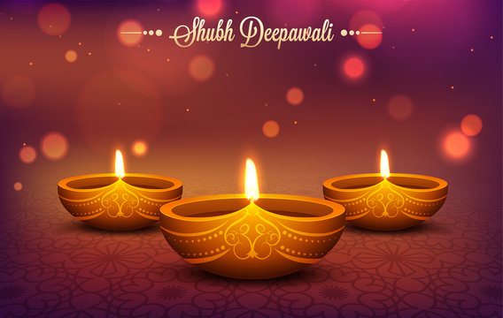Illuminated oil lamps (Diya) on shiny bokeh effect background for Shubh Deepavali festival celebration concept.