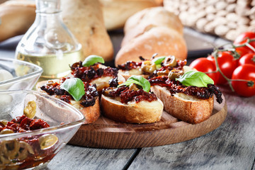 Appetizer bruschetta with sun-dried tomatoes, olives and mozarella.