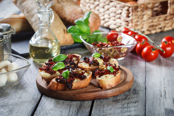 Appetizer bruschetta with sun-dried tomatoes, olives and mozarella.