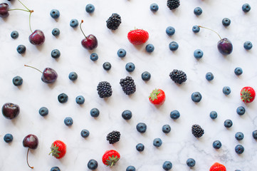 Berries on marble background, top view flat lay
