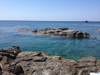 Fototapeta na wymiar Cliff overlooking the Mediterranean sea in a bay at the island of Carloforte in Sardinia, Italy.