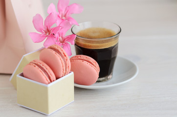 .Black coffee and macarons in box with flowers.Good Morning concept.Copy space.