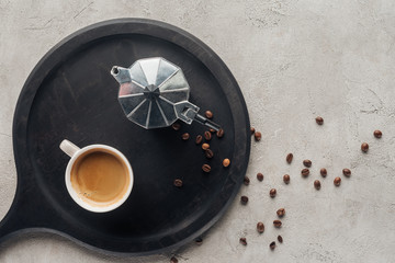 top view of cup of coffee and moka pot on concrete surface