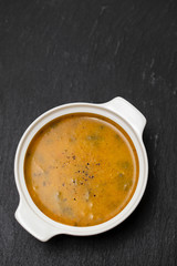 vegetable soup in white bowl on black background