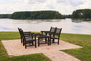 Fototapeta premium Wooden table and chairs for four people to enjoy near river Danube. 