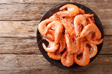 Healthy diet food: boiled wild tiger shrimps close-up on a plate on a table. Horizontal top view - obrazy, fototapety, plakaty