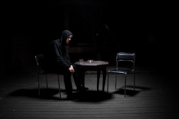 Fototapeta na wymiar Dangerous man sitting alone in the dark