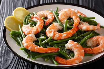 King prawns with green beans, cheese and lemon close-up on a plate. horizontal