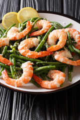 Healthy food: large shrimps with green beans, cheese and lemon close-up on the table. vertical