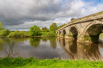 Fototapeta premium Atcham Old Bridge over the River Severn in Atcham, near Shrewsbury, Shropshire, England, UK