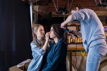 Professional make-up artist and hairdresser working with woman client. Beauty, haircare and make up concept