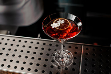 Elegant glass of strong summer cocktail decorated with white flowers