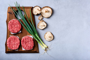 Obraz na płótnie Canvas Fresh raw minced beef, burger patties, cooking ingredients, flat lay