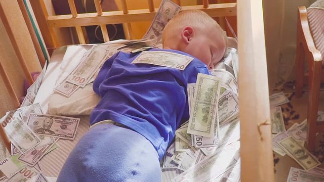 sleeping baby and falling money. Concept unexpected wealth.