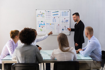 Businessman Explaining Graphs To His Colleagues