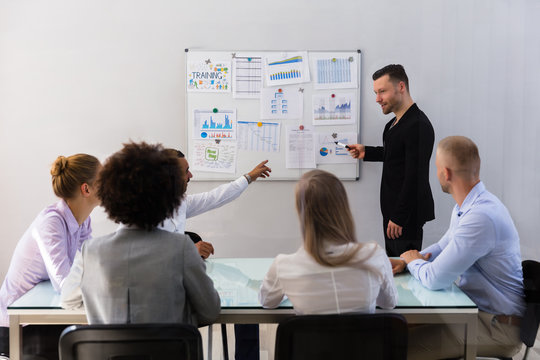 Businessman Explaining Graphs To His Colleagues