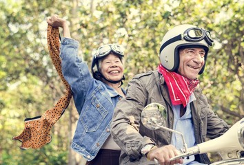 Senior couple riding a classic scooter
