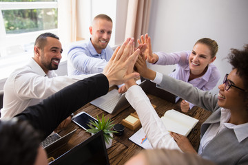 Businesspeople Giving High Five In Office
