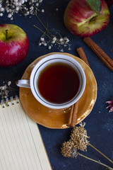 A cup of tea with cinnamon and apples flat lay, autumn mood