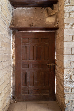 Facade of old abandoned stone bricks wall with grunge weathered wooden door, Old Cairo, Egypt
