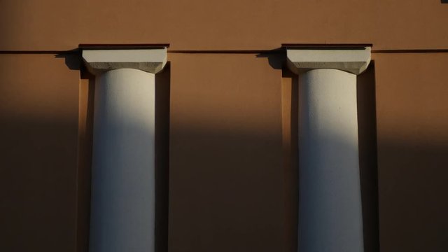Two pilasters are hiding in shadow at the evening