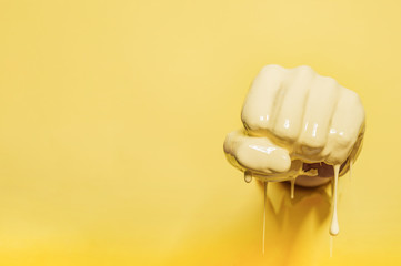 Fist painted with yellow paint pierces the wall