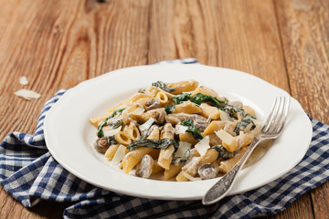 Penne pasta with spinach and mushrooms. Sprinkled with cheese.