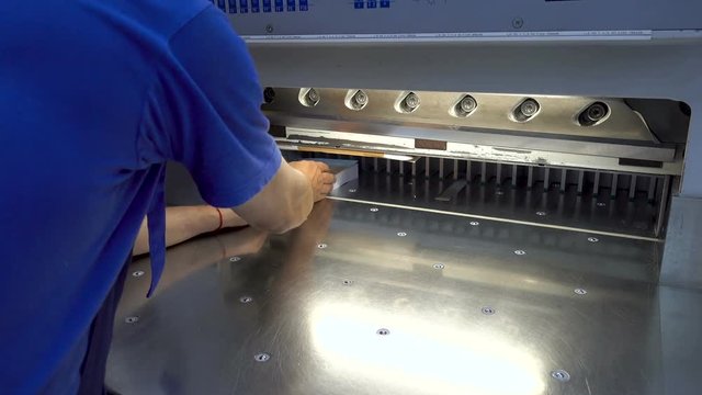 MOSCOW, RUSSIA - August 17, 2018: Printing factory - big industrial cutter for cutting paper shears - guillotine machine - close up 4K.