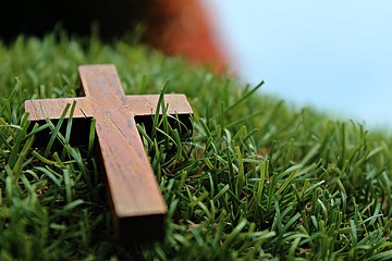 Blurred image. Christian crosses made of wood on a green background.