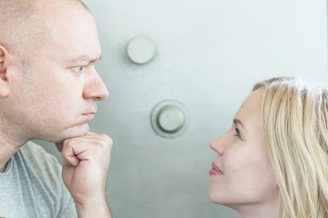 Money relations between a man and a woman. Family budget, family expenses. Husband and wife on the background of the safe.