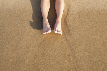 Female legs on sand