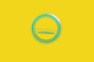 green round plastic ruler lying on a yellow background . concept of office supplies. free space for advertising text