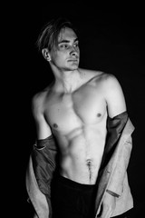 Naklejka premium Portrait of fashion young caucasian sexy muscled attractive handsome athletic man boy model isolated on black background